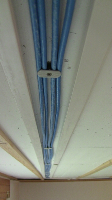 4 blaue Kabel nebeneinander an Betondecke befestigt