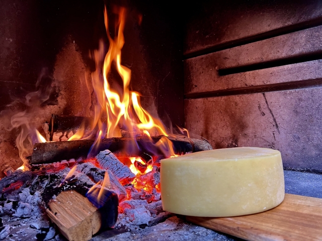 Der Käse zum Schmelzen am Feuer